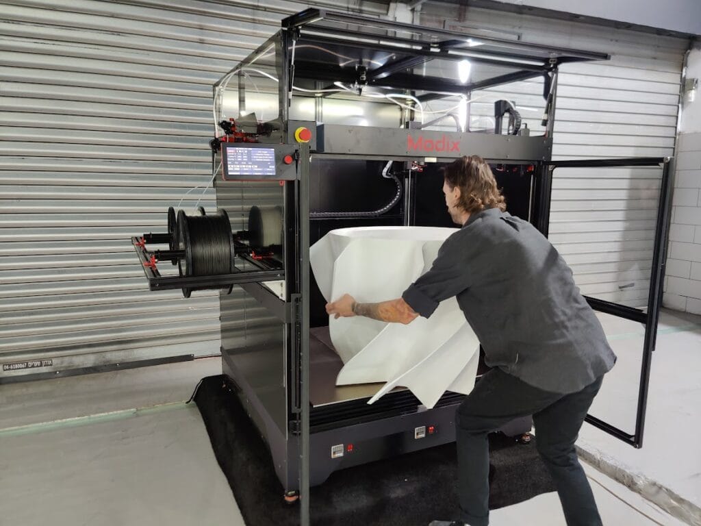 Modix 3D printer – vađenje gotovog 3D printa iz stroja Osoba vadi dovršeni 3D ispis iz Modix 3D printera velikog formata